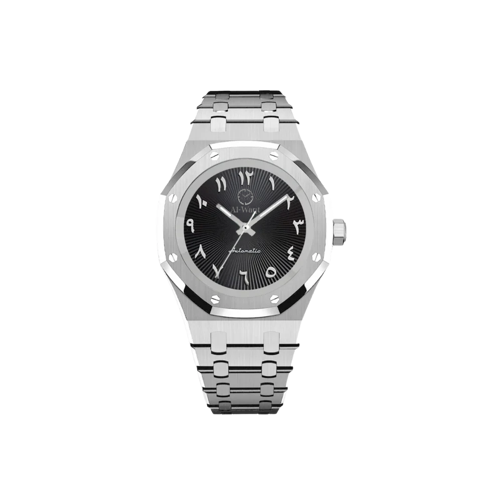 Montre avec boitier et braceler argenté. Les aiguilles sont elles aussi argentées et le cadran, lui, noir avec des chiffres arabes. Au dessus de centre se trouve le logo de la marque Al-Waqt.