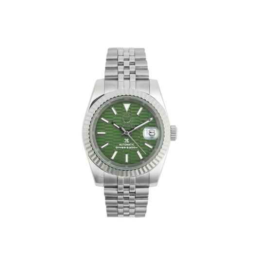 Montre avec un bracelet couleur argent, un cadran vert écaillé qui joue avec les textures. Un petit hublot pour voir la date et des aiguilles aussi argentés.  